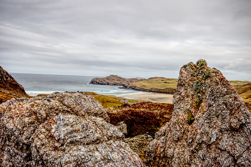 Looking down to Cliff Beach in UIG on the Isle of Lewis Scotland through outcrops of Lewisian Gneiss rock