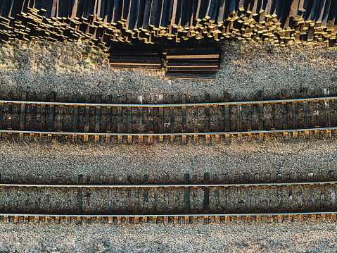 New railroad ties stacked along two rail lines.