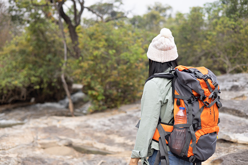 Middle age hiker enjoy the beautiful landscape at mountain , Female hiker backpack to rest on big rock in forest. Healthy lifestyle adventure travel