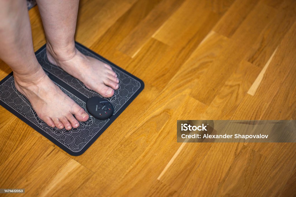Close Up View Of Womans Feet On Electrical Ems Foot Massager Pad Feet  Acupuncture Simulator Sweden Stock Photo - Download Image Now - iStock
