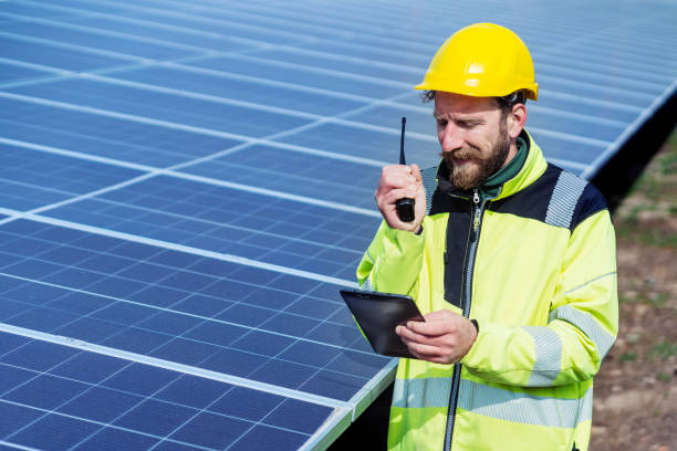 istock Male electrical engineer with a tablet reporting a problem in the solar power station with a walkie-talkie 1474613721