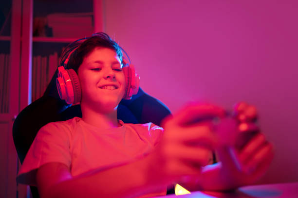 istock Little boy with gamepad playing video game at home 1474614577