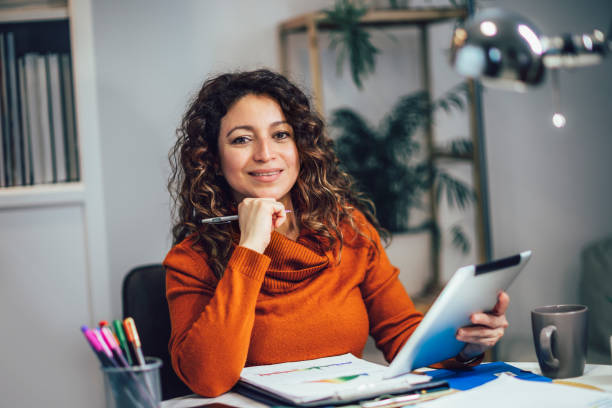 istock Attractive woman working on a tablet in a home office. 1474615223