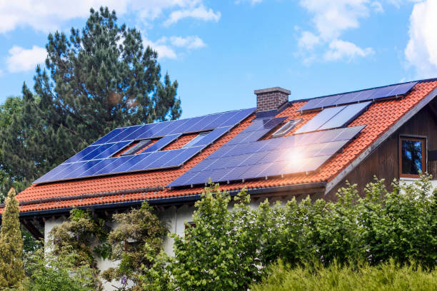 Solar Panels on House Roof with Sun Reflection Solar Panels on House Roof with Sun Reflection and Green Landscape. Eco House in Green City concept. solar power station solar panel house solar energy stock pictures, royalty-free photos & images