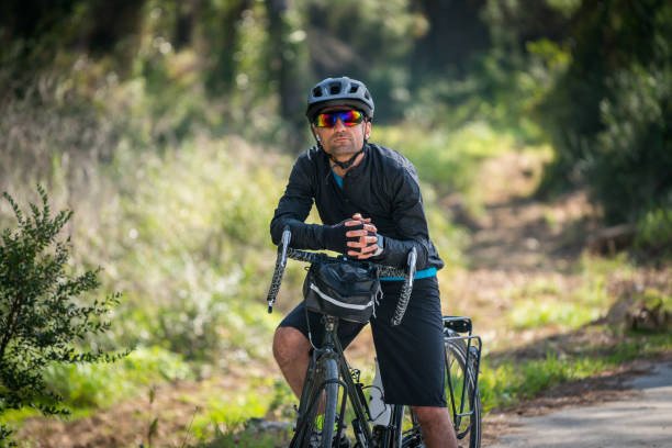 istock Professional cyclist riding bicycle forest on asphalt road 1474616649