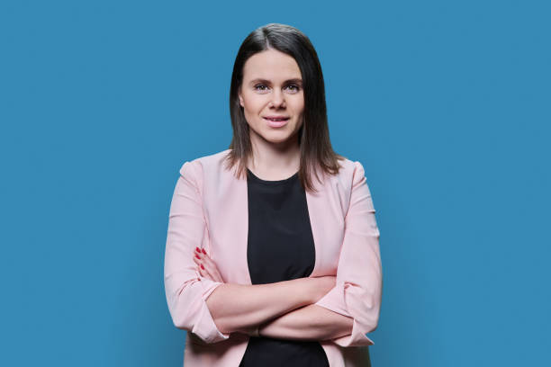 istock Confident business young female looking at camera on blue background 1474619738