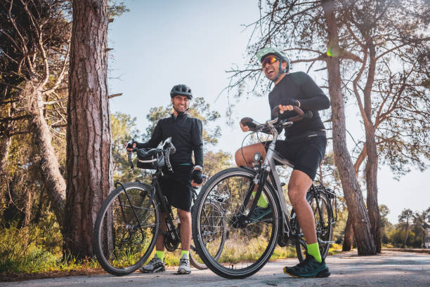 istock Two male professional cyclists with their bikes setting direction for exercise on forest road 1474619787