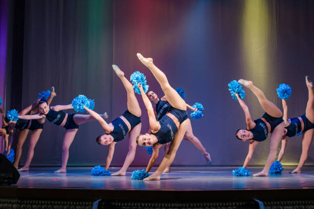 istock athletes perform on stage, young cheerleaders perform at the cheerleading championship, leg raised up, girl doing acrobatic and flexible tricks, girls dancer practicing mixed dance and stretching 1474620603