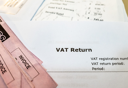 Close up of a British value added tax document with invoices on a desk.