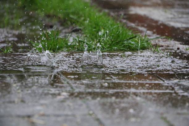 istock rain is falling and splashing on the asphalt in the garden 1474622133