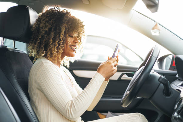 istock afro woman using smartphone before starting her travel in car 1474622215