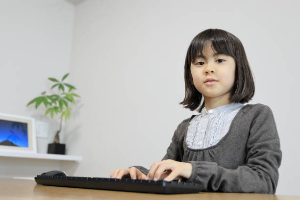 istock Japanese student girl typing PC keyboard (8 years old) 1474622673