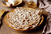 lace pancakes on a yellow clay plate, on the table