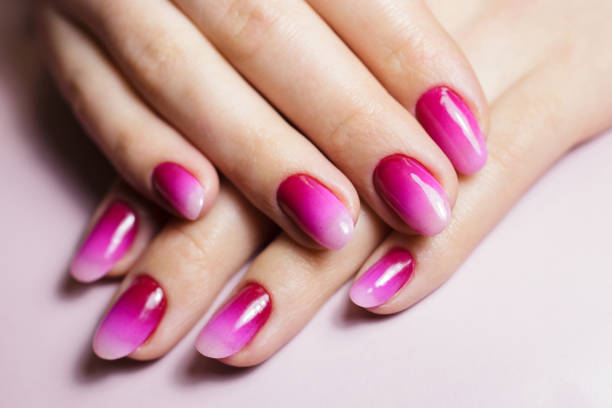 istock Nail design, manicure with gel polish. Women's hands with a gradient pink manicure. 1474626976
