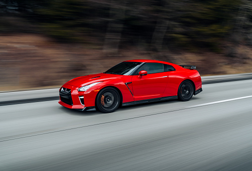 Seattle, WA, USA
March 19, 2023
Red Nissan GTR driving on the street showing the front side of the car