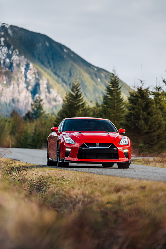 Seattle, WA, USA\nMarch 19, 2023\nRed Nissan GTR parked on a road with a mountain in the background
