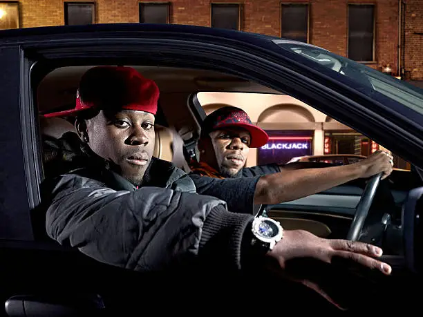 Gang/rappers strolling the streets in their car