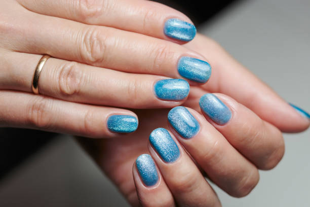 Fashionable nail design with metallic particles. Applying a magnetic field to create a pattern.