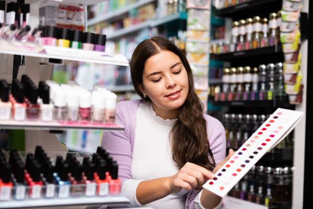 istock Girl choosing nail polish from color samples in makeup store 1474632533