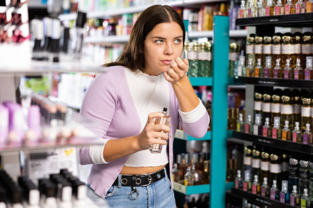 istock Girl smelling perfume tester in cosmetics store 1474633097