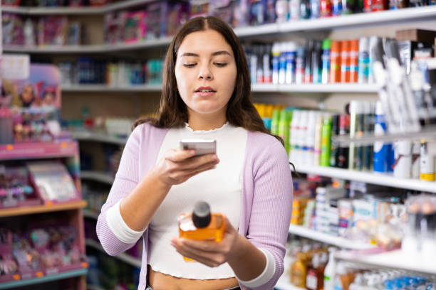 istock Female shopper scanning a QR code using a mobile phone in cosmetics store 1474633113