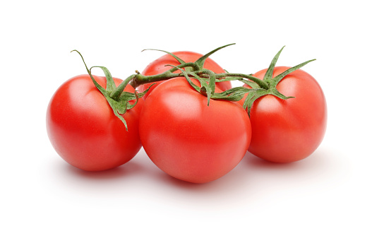Group of ripe tomatoes with leaves isolated on white.