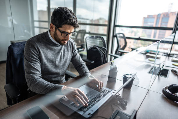 istock Mid adult businessman working using laptop at office 1474636715