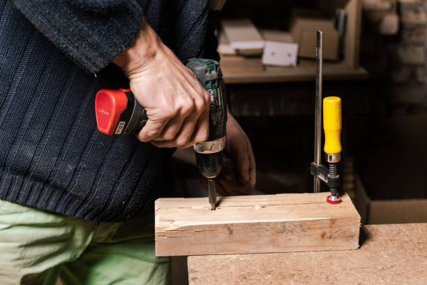 istock A carpenter works in a furniture workshop with various tools and a board 1474636996