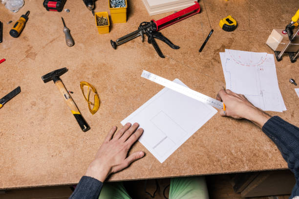 istock A carpenter works in a furniture workshop with various tools and a board 1474637537