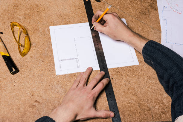 istock A carpenter works in a furniture workshop with various tools and a board 1474637541
