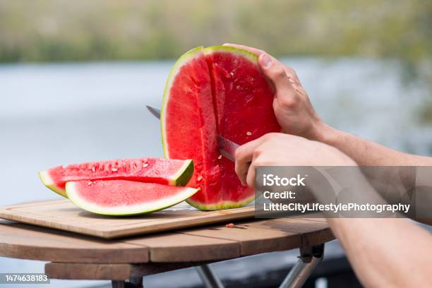 Cutting Up Fresh Watermelon By The Lake Stock Photo - Download Image Now - Watermelon, Cutting, Eating