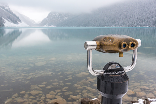 Binoculars overlooking Lake Louise on a foggy, misty day in Banff National Park, Alberta, Canada