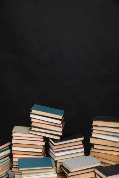 science knowledge reading many books in stacks in the library on black background