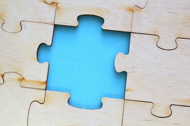 istock Incomplete and absence wooden puzzle piece with blue backdrop. Missing piece. Mental health concept. Symbol of problem solving 1474643305