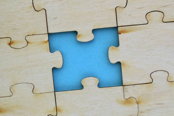 istock Incomplete and absence wooden puzzle piece with blue backdrop. Missing piece. Mental health concept. Symbol of problem solving 1474643957