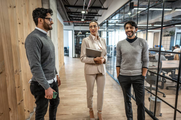istock Coworkers talking in corridor at office 1474648846