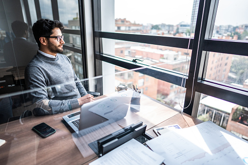 Mid adult businessman contemplating at office