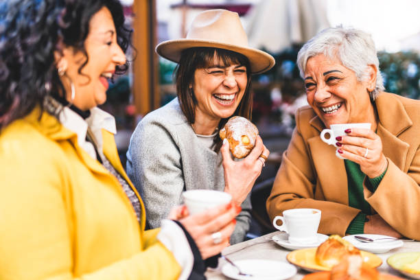 gruppe älterer frauen in der bar-cafeteria frühstücken, kaffee trinken und croissant essen - lifestyle-konzept - reife frau, die spaß im bistro-café hat und zeit miteinander verbringt - coffee couple italy drinking stock-fotos und bilder