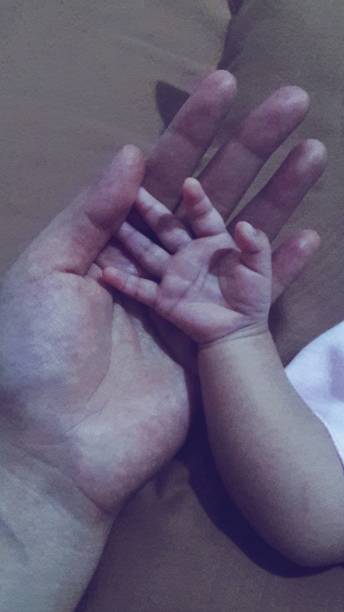 istock Mom Holding Baby Hand 1474666933