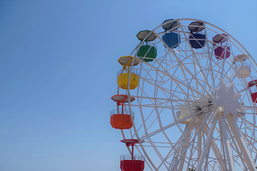 Colorful Ferris wheel with clear blue sky in the background in Parc d'atraccions Tibidabo in Barcelona, Spain
