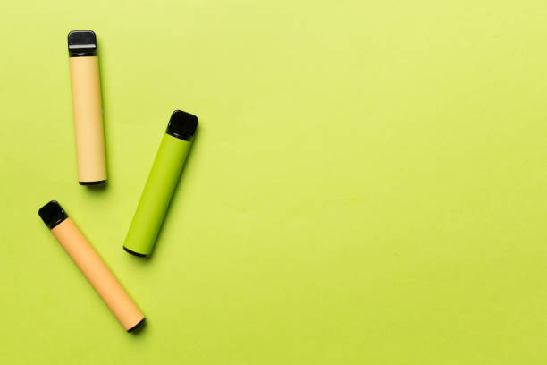 istock Disposable electronic cigarettes on color background, top view 1474676909