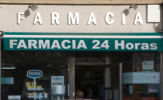 Lugo ,Spain_ January 19,2011: Pharmacy 24 hours sign in spanish language, awning, store window in the sunlight, front view .