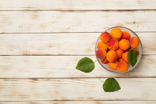 Composition with ripe apricots on wooden background, top view.