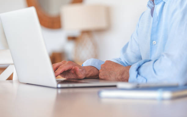 istock Close up of a mature man typing on a computer. 1474689121