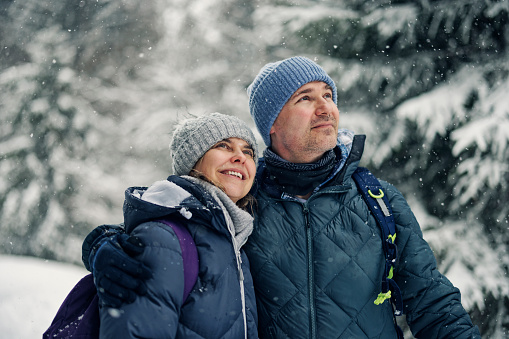 Portrait of middle aged couple hiking in beautiful European Alps mountains on an overcast  winter day\nShot with Canon R5