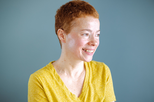 Young beautiful blonde woman over yellow background happy face smiling with crossed arms looking at the camera. Positive person.