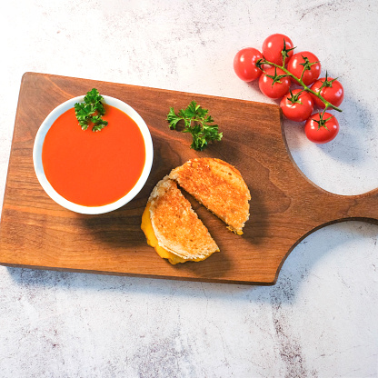Tomato Soup And A Grilled Cheese Sandwich On A Wooden Board