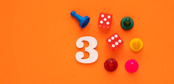 istock Number three in white with pieces and gambling dice - Orange eva rubber background 1474698511
