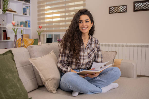 istock Woman reading book at home 1474703370