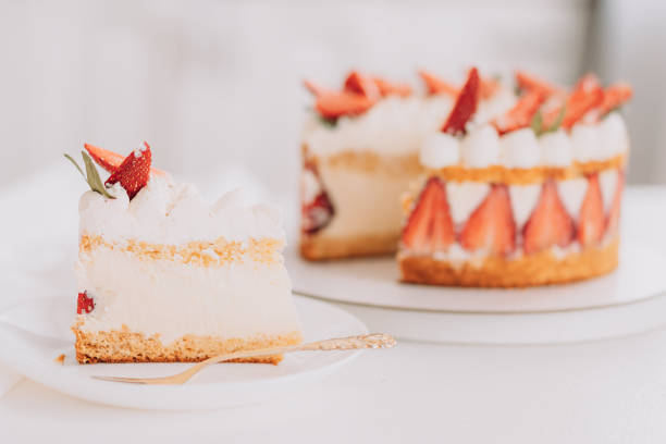 istock Sliced piece opposite mousse cake with strawberries on white table 1474707720